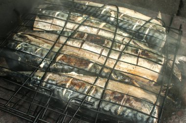 Kırsal ev şömine closeup beyaz duman ile demir tepside Uskumru balığı ızgara