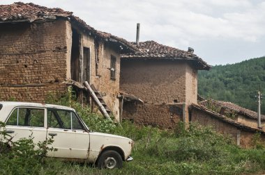 Eski terk edilmiş yıpranmış retro vintage kırsal tuğla duvar evleri kırsal köy ve eski yıpranmış terk edilmiş ihmal edilen paslı kırık eski model eski araba