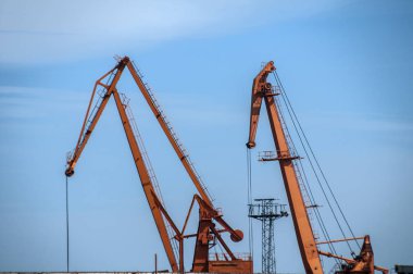 Mavi gökyüzü arka planda nehir limanı vinç tesisleri ile endüstriyel sahne