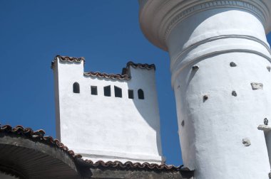 Güzel mavi gökyüzü arka plan üzerinde eski bir evin çatısında beyaz sıva baca ve kule ile sıvalı