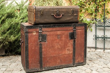 Eski retro ahşap göğüs ve vintage grunge bavul taş döşeli ev arka bahçesinde izole