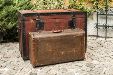 Eski retro ahşap göğüs ve vintage grunge bavul taş döşeli ev arka bahçesinde izole