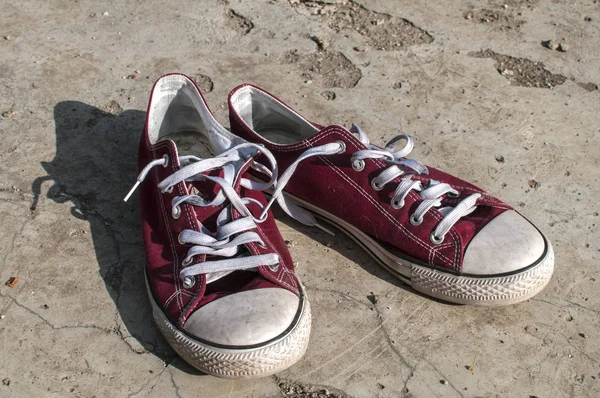 Dış Beton Yüzeyinde Yıpranmış Vintage Kırmızı Eski Tuval Spor Ayakkabı — Stok fotoğraf