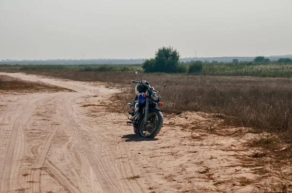 オートバイは晴れた夏の日に捨てられた砂の道で止まった — ストック写真