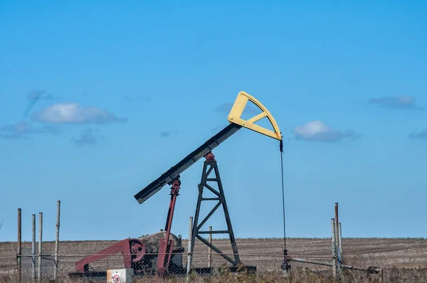 Opetating petrol oil well pump jack in summer sunny day