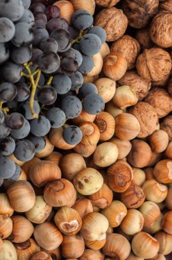 Olgun çiğ fındık, ceviz ve kırmızı üzüm arka plan olarak yakın plan.
