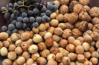 Olgun çiğ fındık, ceviz ve kırmızı üzüm arka plan olarak yakın plan.