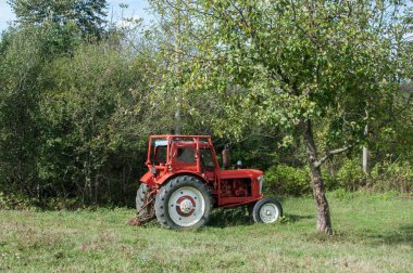 Güneşli bir günde kırsal tarım çayırında klasik traktör kapanışı.