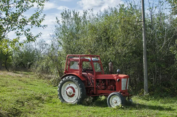 Vintage tractor closeup on rural farm meadow in sunny day