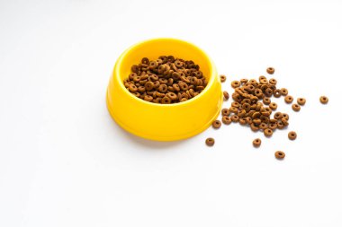 Beyaz arka planda izole edilmiş kuru köpek mamasıyla dolu sarı plastik kase. Yazı dizaynının kopyası olan en iyi tahıllı evcil hayvan yiyeceği. Üst ya da Üst Manzara. yiyecek dokusu pankartı
