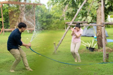 Genç Asyalı çiftler evlerinde hortumla birbirlerine su sıkarmış gibi yapıyorlar. Mutlu aile kavramı. Açık havada aşık gülümseyen bir çift