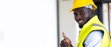 Depoda çalışan işçi sürücü forklift. Depoda forkliftle kart kutuları istifleyen bir depo çalışanı. Afrikalı Amerikalı siyahiler.