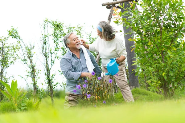 Asian elderly couple Water the plants in garden at home. Happy senior people at home. Happy family concept.