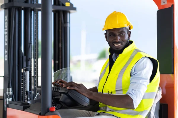 Warehouse man worker driver forklift. warehouse worker driver stacking card boxes by forklift in warehouse store. African American black people.