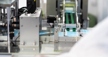 Makineler steril bir fabrikada maske üretmek için çalışıyor. Tıbbi maske üretimi. bir maske üretme süreci