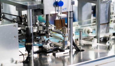 Makineler steril bir fabrikada maske üretmek için çalışıyor. Tıbbi maske üretimi. bir maske üretme süreci