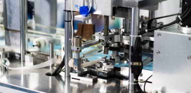 Makineler steril bir fabrikada maske üretmek için çalışıyor. Tıbbi maske üretimi. bir maske üretme süreci