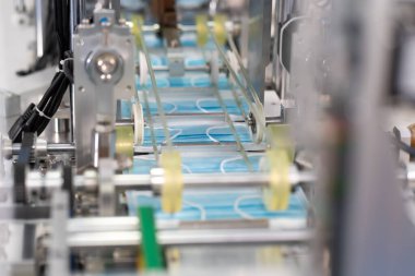 Makineler steril bir fabrikada maske üretmek için çalışıyor. Tıbbi maske üretimi. bir maske üretme süreci