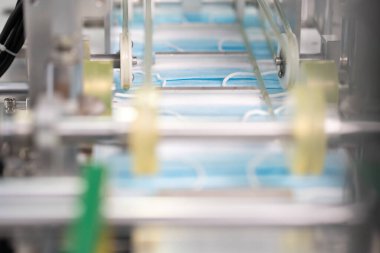 Makineler steril bir fabrikada maske üretmek için çalışıyor. Tıbbi maske üretimi. bir maske üretme süreci