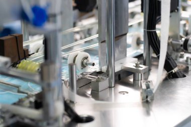 Makineler steril bir fabrikada maske üretmek için çalışıyor. Tıbbi maske üretimi. bir maske üretme süreci