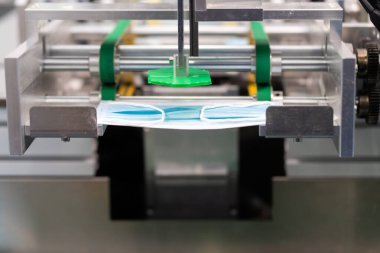 Makineler steril bir fabrikada maske üretmek için çalışıyor. Tıbbi maske üretimi. bir maske üretme süreci