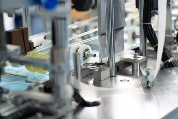 Машины работают для производства масок на стерильной фабрике. Производство медицинских масок. процесс изготовления маски