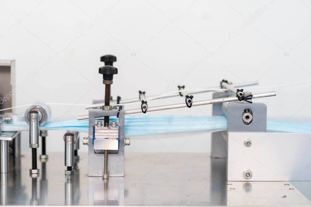 Machines are working for producing masks in a sterile factory. Production of medical masks. process of manufacturing a mask