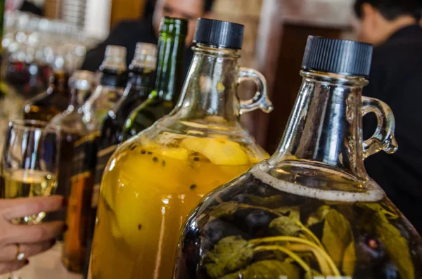 Deux grandes bouteilles en verre de pisco aux fruits macérés — Photo