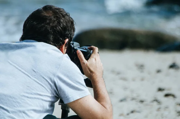 Genç adam deniz sahilde kamera çekimi resimli. — Stok fotoğraf