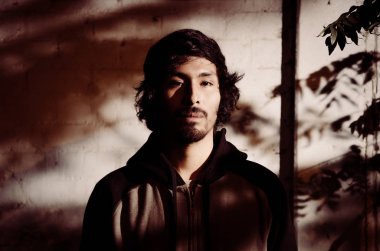 Genç adam gömlek giymiş sakallı ve ağaçların gölgeleri ile portresi