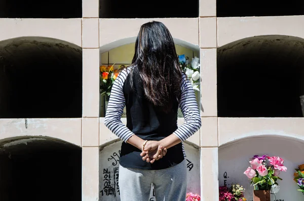 Mujer desde atrás contemplando la tumba de un ser querido — Foto de Stock