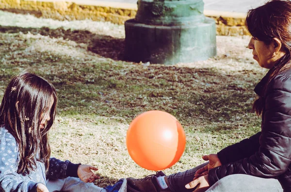 Madre e hija jugando pelota en el césped en el parque . — Foto de Stock