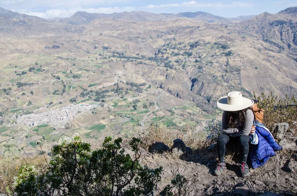 Mujer viajera sentada en una roca con el fondo de la ciudad de Canta —  Fotos de Stock