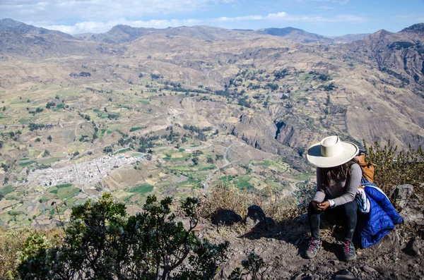 Mujer viajera sentada en una roca con el fondo de la ciudad de Canta —  Fotos de Stock