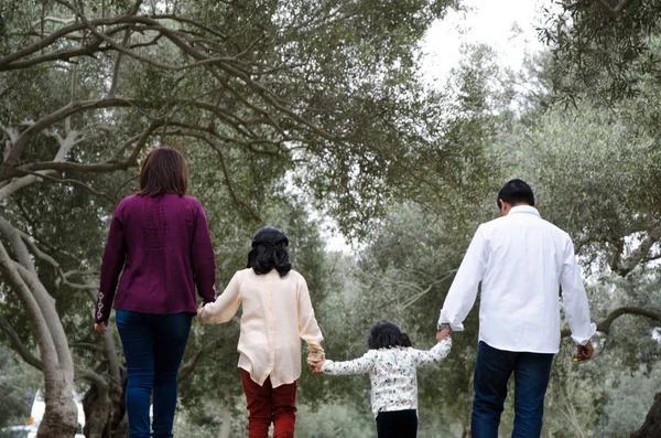Familia feliz en la luz del atardecer de invierno del parque. Mamá, papá y niños felices caminan al atardecer . — Foto de Stock