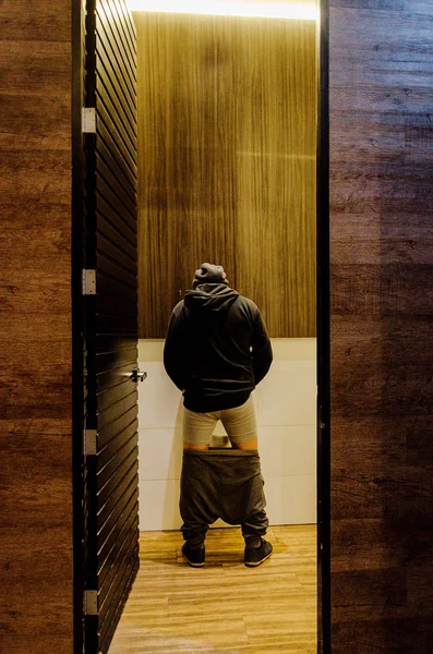 Hombre de pie orinando a un urinario en el baño o concepto de incontinencia — Foto de Stock