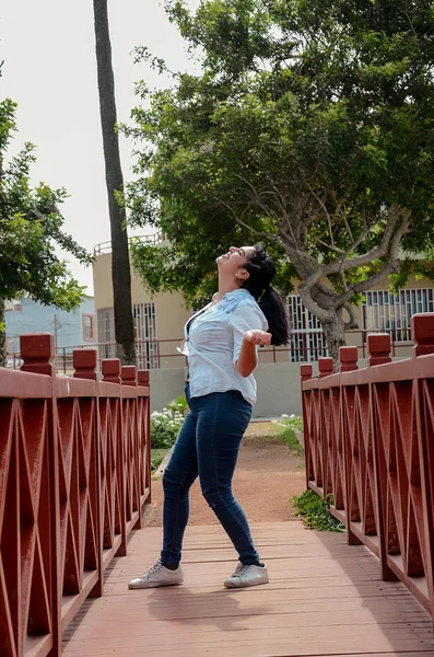 Very pretty plump woman standing on a bridge