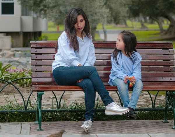 Mère et sa petite fille assises sur un banc — Photo