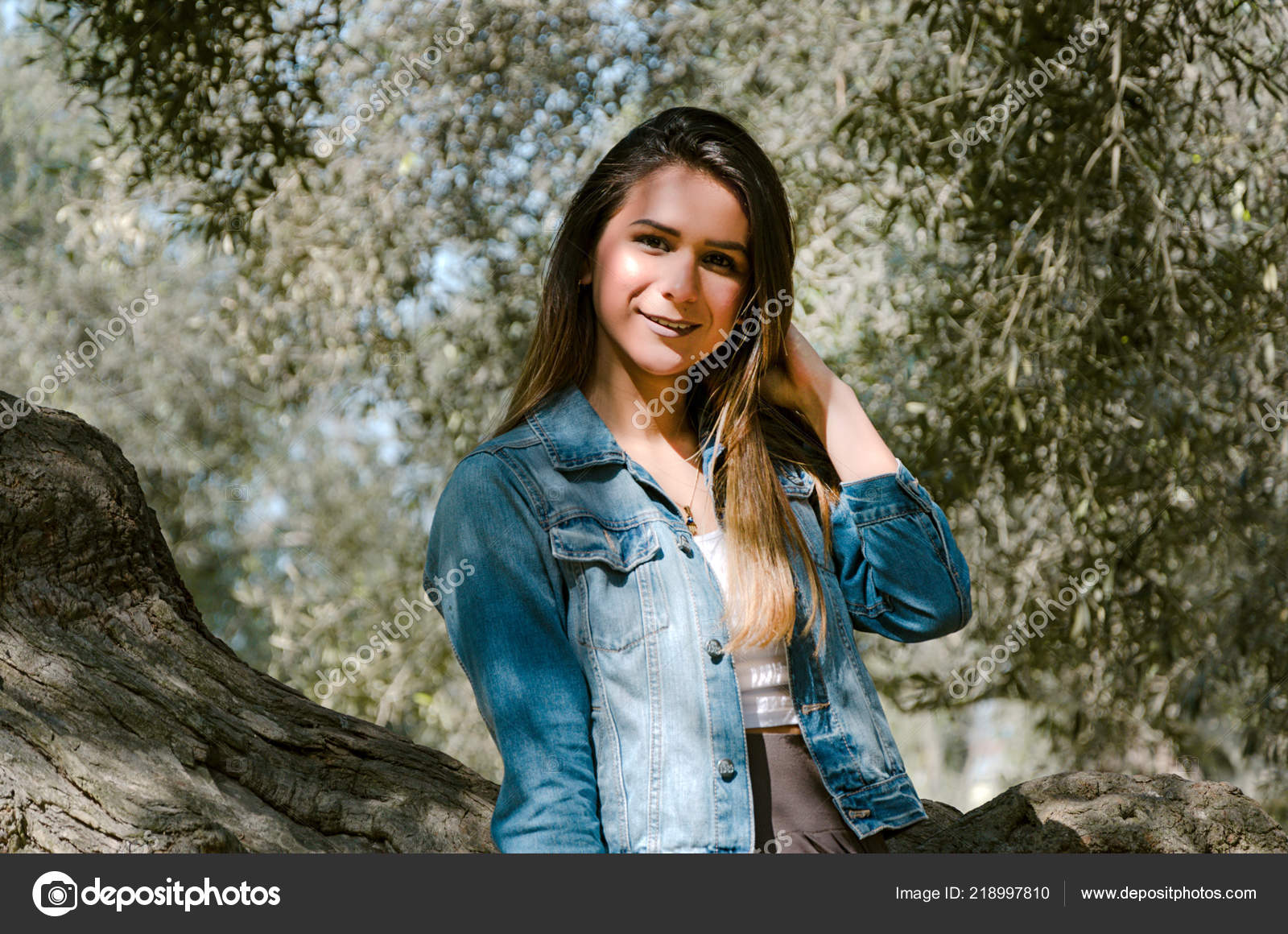 Beautiful Long Haired Teen Woman With Brown Hair Leaning On A Tree