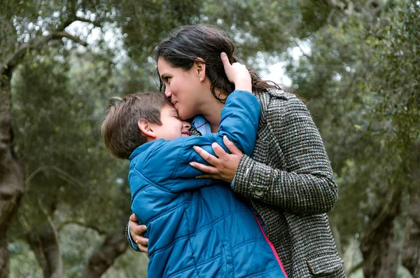 Retrato de una madre besando a su hijito en el parque — Foto de Stock