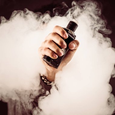 Adamın elini mod siyah bir arka plan ile duman yükselir.