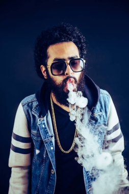 Bir mod tutarak Vaping adam. Buhar bulutu. Siyah arka plan. Vaping çok duman ile elektronik sigara.