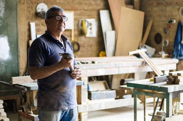 Retrato del carpintero senior. De pie en su taller . —  Fotos de Stock