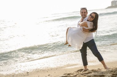 genç adam kız arkadaşı kollarında taşıyan