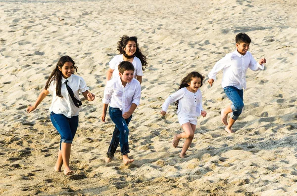 Enfants courant le long du rivage de la plage — Photo