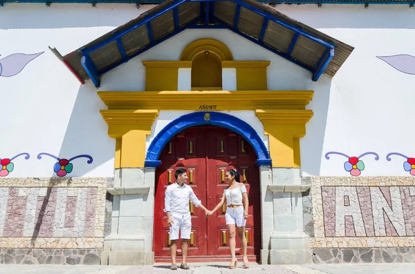 Счастливая красивая женщина со своим парнем, смотрящим друг на друга у дверей церкви Антиокии к востоку от Лимы — стоковое фото