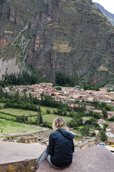 Turista posando sobre las rocas en la cima de los escalones de la antigua fortaleza Inca de Ollantaytambo en el Valle Sagrado del Cusco —  Fotos de Stock