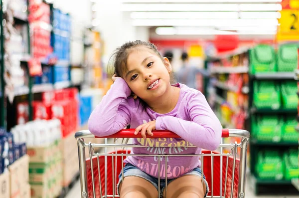 Продажа, потребительство и люди концепция - счастливая маленькая девочка в корзине — стоковое фото