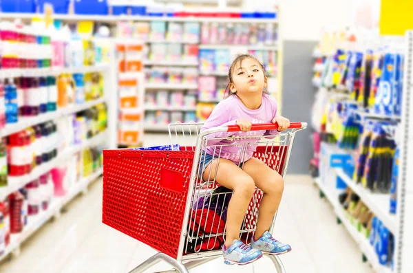 Продажа, потребительство и люди концепция - счастливая маленькая девочка в корзине — стоковое фото