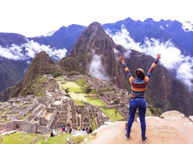 Machu Picchu arka planda yükseltilmiş silah ile genç kadın.
